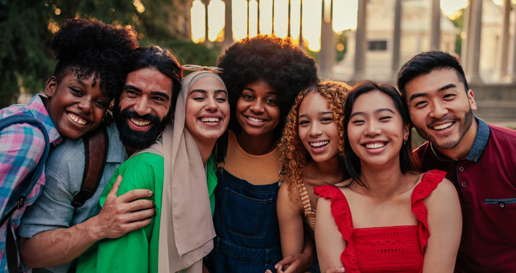 Photo of a group of multicultural young adults posing for a photo and smiling