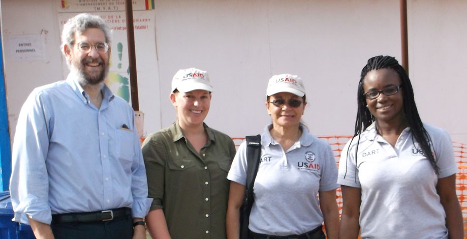 Berzon with DART-USAID colleagues outside an Ebola treatment unit – NOTE: Image is prohibited for reuse