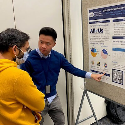NIMHD postbac Vincent Lam explains the U.S. health disparities browser he developed to an attendee at the 2023 Postbac Poster Day