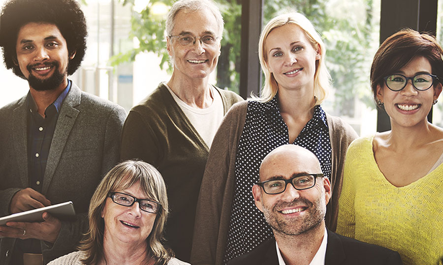 A smiling group of people of different genders, ages, races and ethnicities.