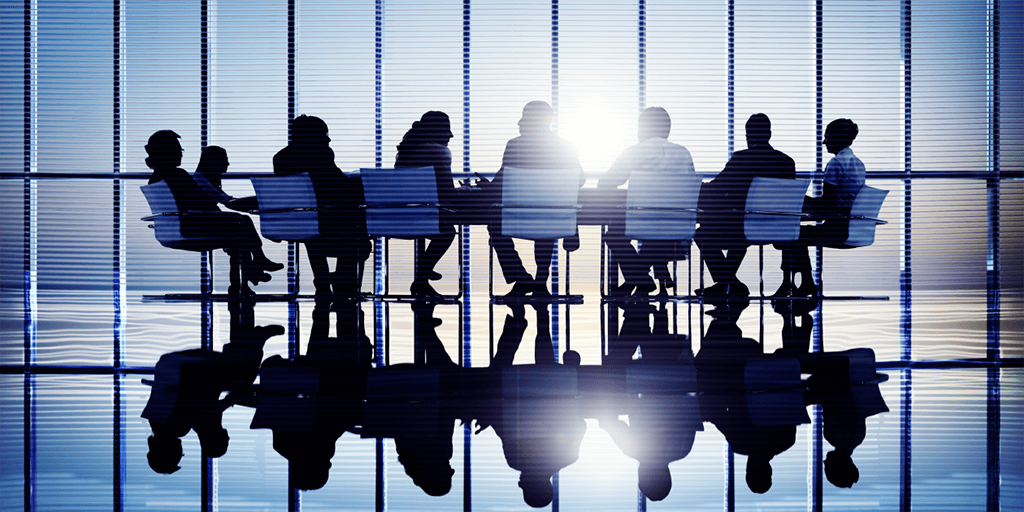 Silhouette view of a group of men and women around a meeting table