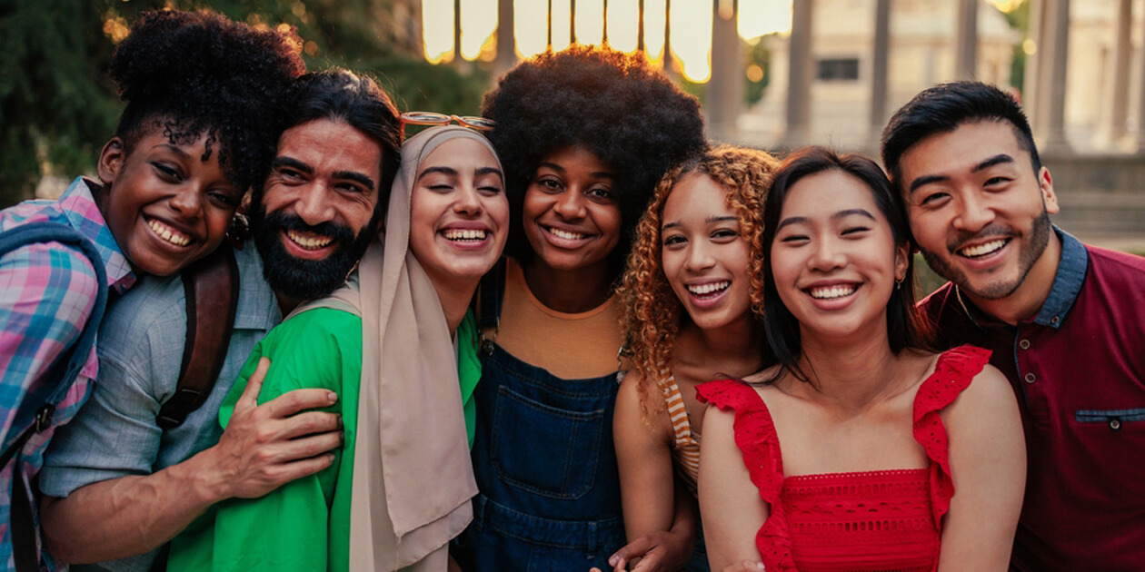Photo of a group of multicultural young adults posing for a photo and smiling
