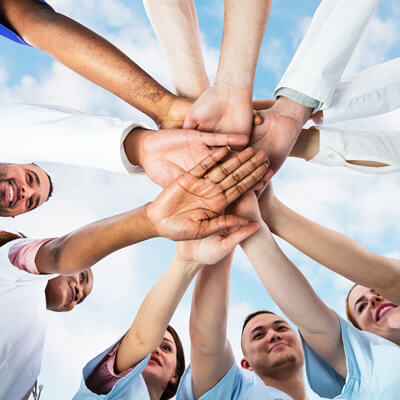 Photo: A diverse medical team of professionals with hands stacked together