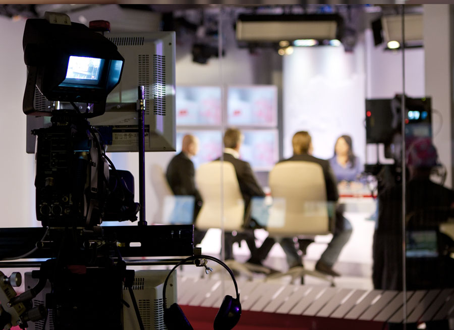 Group of people being interviewed on a television set.