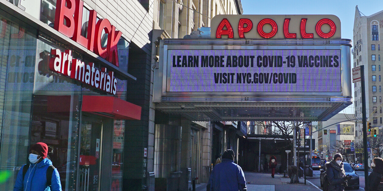 In Harlem, the Apollo Theater marquee says Learn more about covid-19 vaccines, visit nyc.gov/COVID.